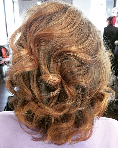 Curly red head with highlights and lowlights. – Kenneth Wildes Salons
